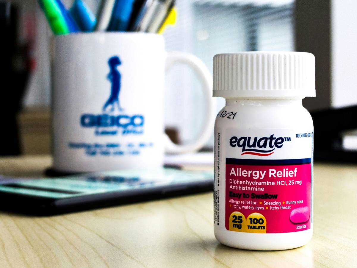 Bottle of severe back pain relief tablets next to spine model showing targeted relief zones