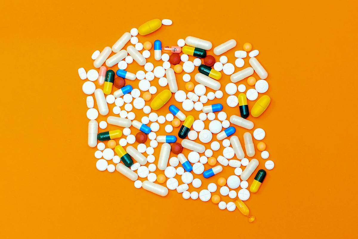 Person performing gentle spinal twist exercise at desk alongside severe back pain relief tablets